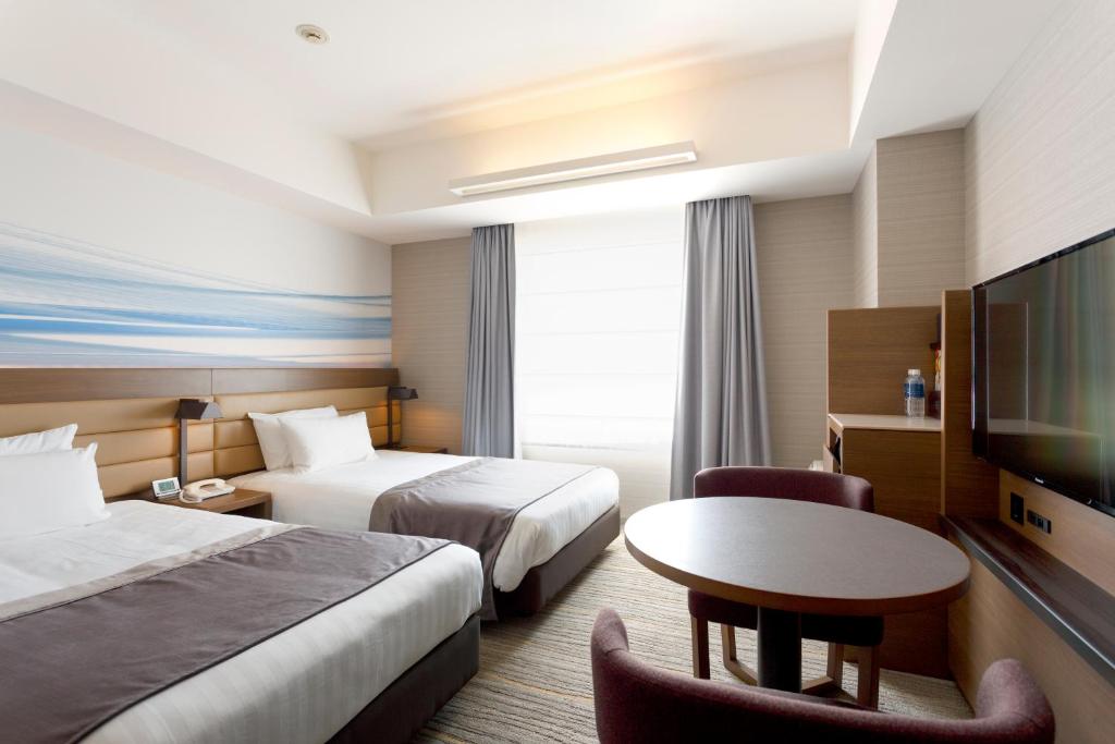 a hotel room with two beds and a table and a tv at Haneda Excel Hotel Tokyu Haneda Airport Terminal 2 in Tokyo