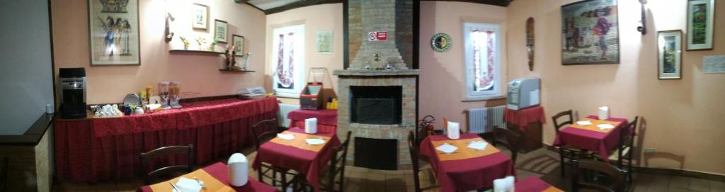un restaurante con mesas y una chimenea en una habitación en Albergo Airone, en Ostellato