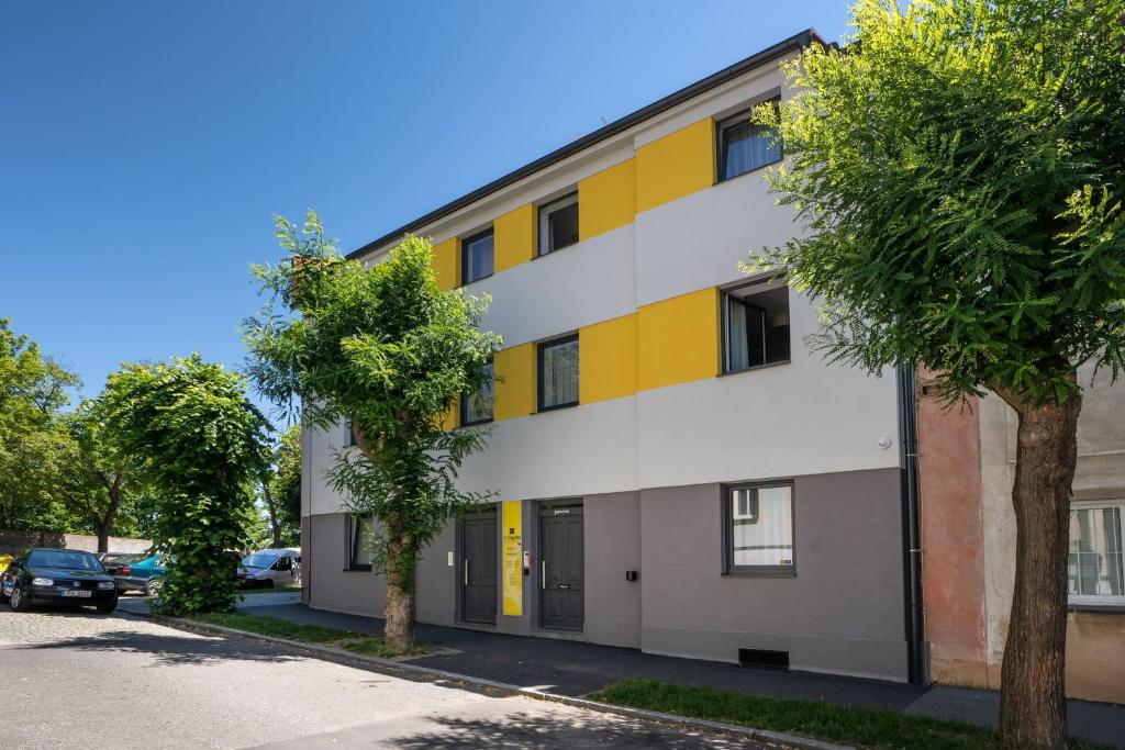 un edificio de apartamentos con fachada de color amarillo y blanco en Wellness penzion U GIGANTU, en Plzeň