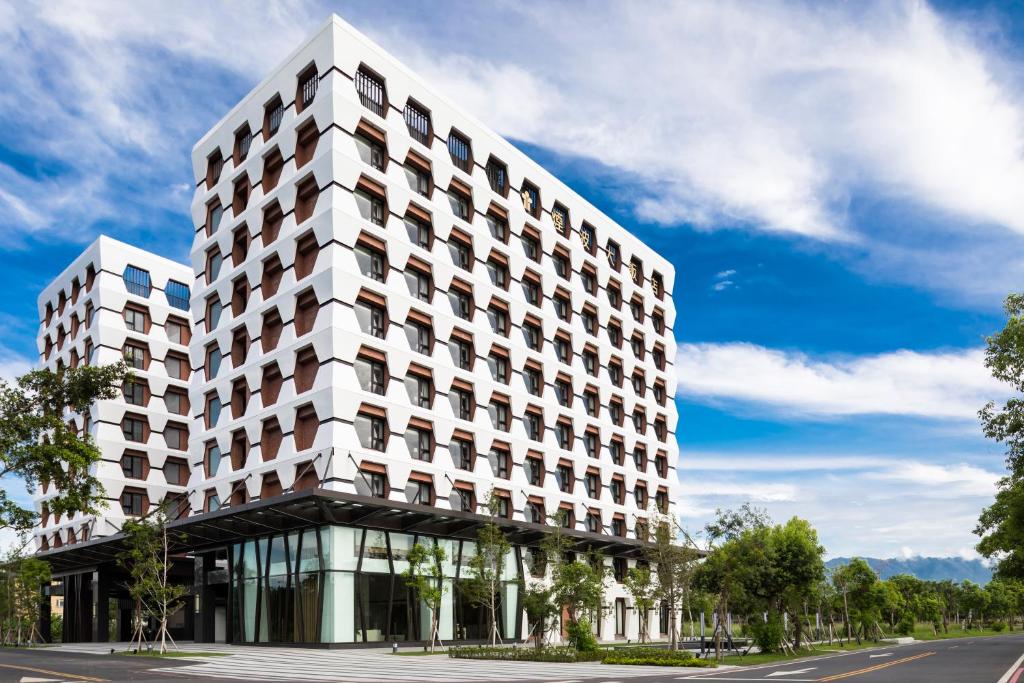 ein großes weißes Gebäude an der Straßenseite in der Unterkunft Lakeshore Hotel Yilan in Yilan