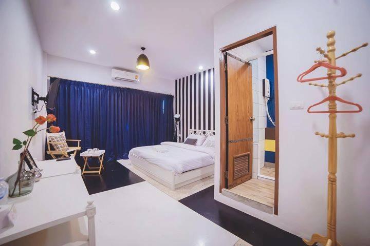 a room with a mirror and a bed and a bedroom at Urban-Bamboo in Nakhon Ratchasima