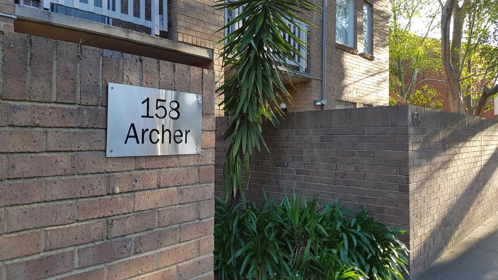 un panneau sur le côté d'un bâtiment en briques dans l'établissement North Adelaide Apartment, à Adélaïde