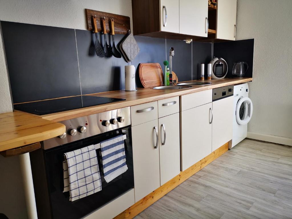 a kitchen with white cabinets and a stove top oven at Landidylle Mertensdorf - Ferienwohnung in Triglitz