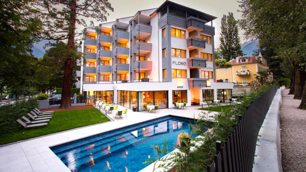 een hotel met een zwembad voor een gebouw bij Flora Hotel & Suites in Merano