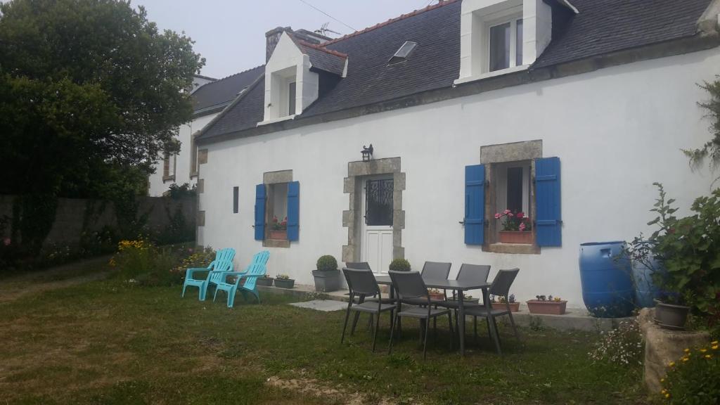 un groupe de chaises et une table devant une maison dans l'établissement LE PENTY BRETON, à Plouhinec