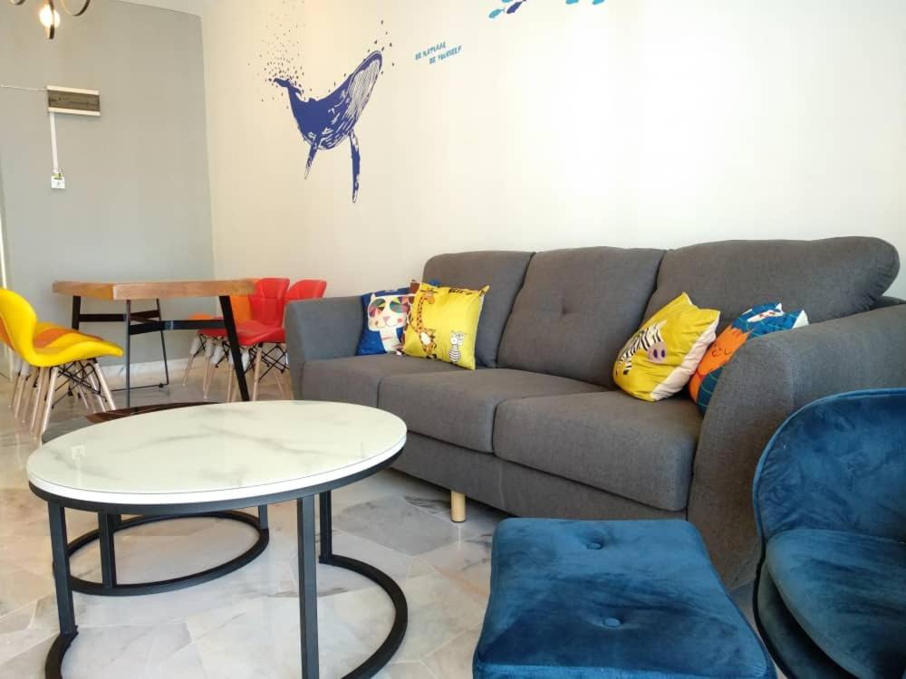 - un salon avec un canapé, une table et des chaises dans l'établissement The Whale - Bayview - Pool open, à Port Dickson