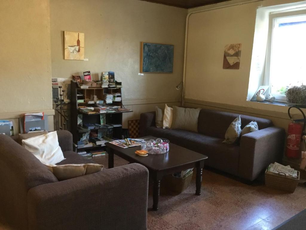 ein Wohnzimmer mit 2 Sofas und einem Couchtisch in der Unterkunft Auberge Fleurie in Saint-Nizier-sur-Arroux