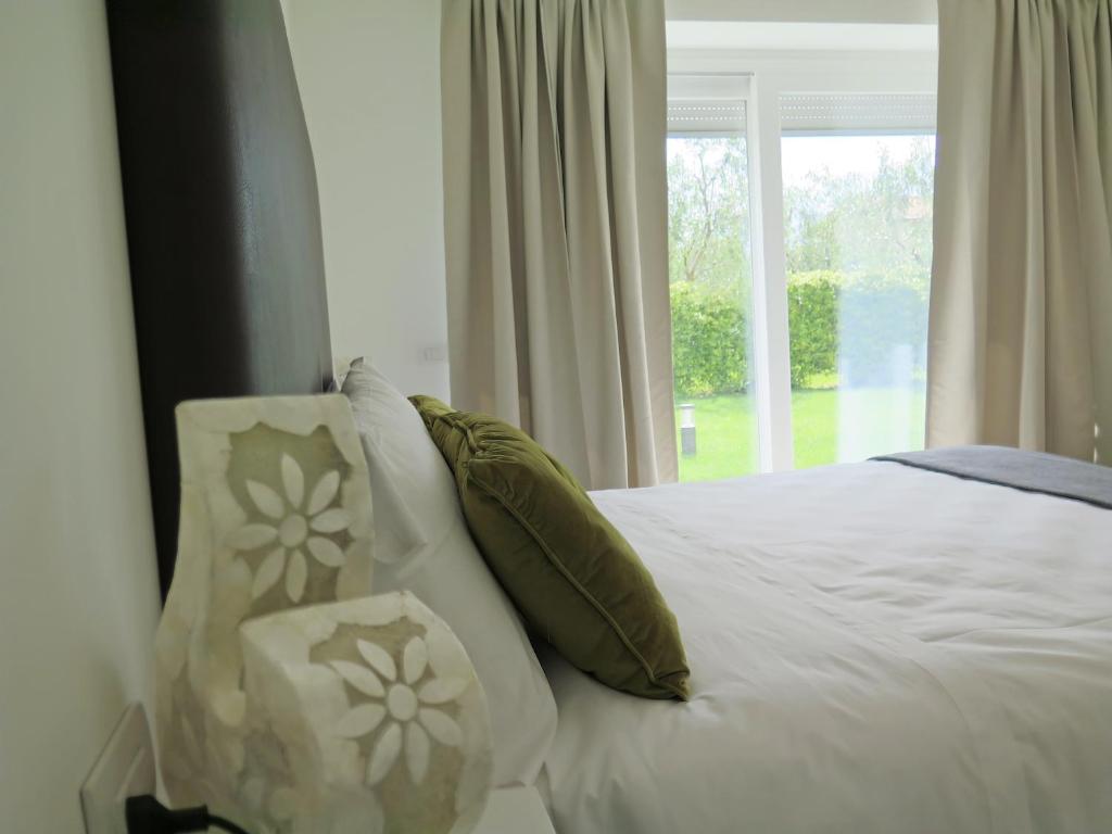 - une chambre avec un lit doté d'oreillers et d'une fenêtre dans l'établissement Casa 32, à Nago-Torbole