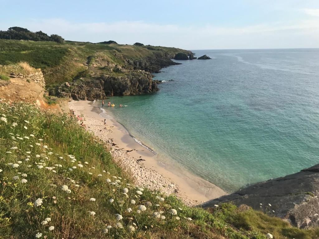 a beach with people swimming in the ocean at Le Clos de la Pointe Saint-Mathieu in Plougonvelin