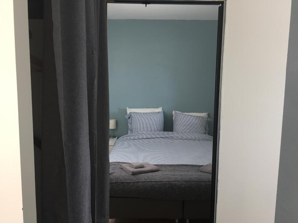 een slaapkamer met een wit bed en een spiegel bij Appartement Design VII Port de Tréboul-Douarnenez in Douarnenez
