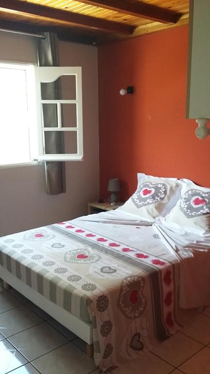 uma cama num quarto com uma parede laranja em Ambiance sud sauvage em Saint-Joseph