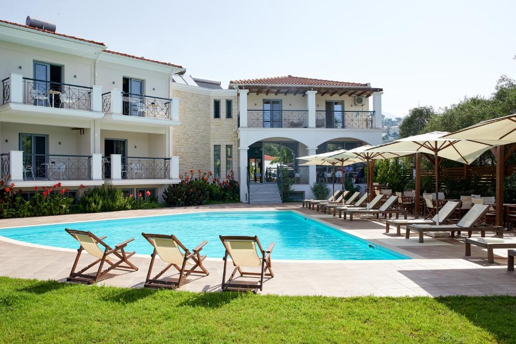 Villa con piscina con sillas y sombrillas. en Sappho Hotel, en Parga