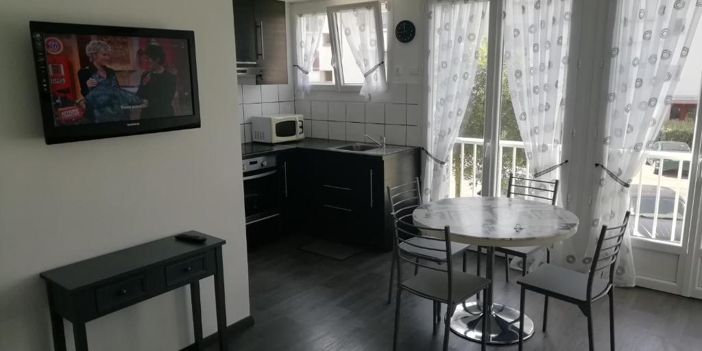a small kitchen with a table and chairs and a microwave at Appartement Le Tréport Centre in Le Tréport
