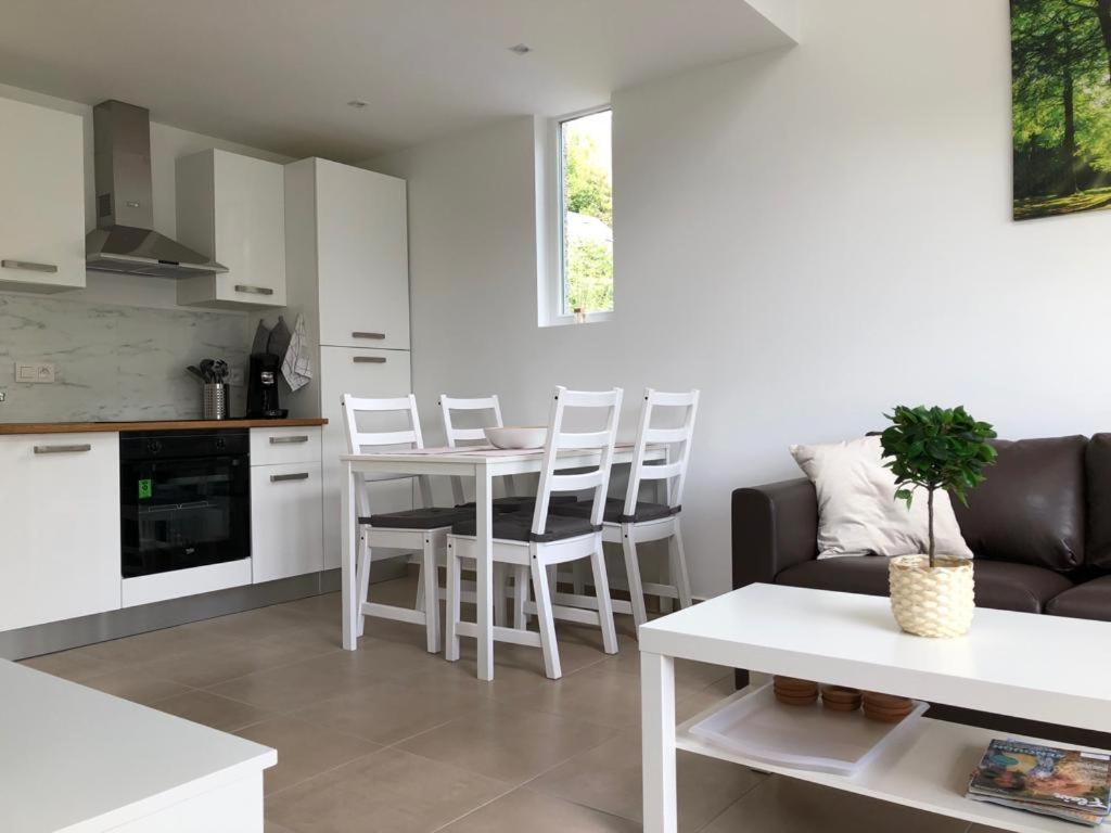 een keuken en een woonkamer met een tafel en stoelen bij Les terrasses de Malmedy duplex 428 in Malmedy
