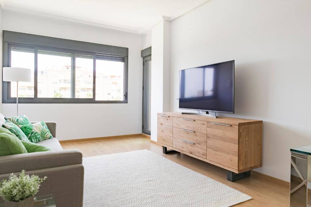 - un salon avec une télévision à écran plat sur une commode en bois dans l'établissement Apartamento Málaga Litoral Beach II, à Malaga