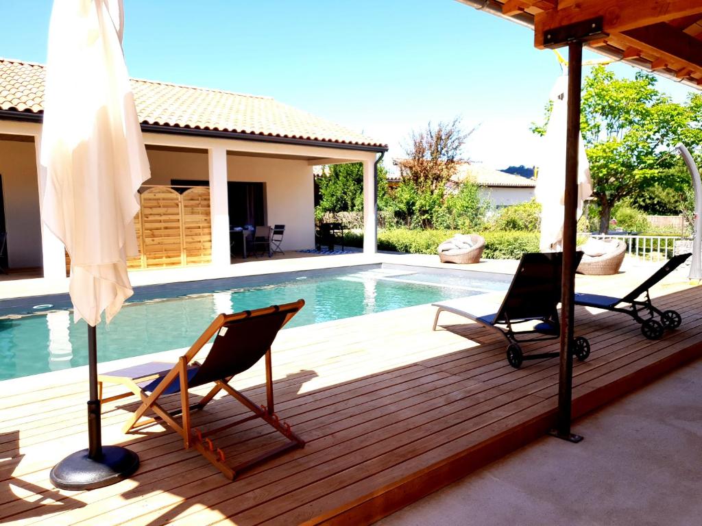 une terrasse avec deux chaises et une piscine dans l'établissement Gîtes de Maurs, à Maurs