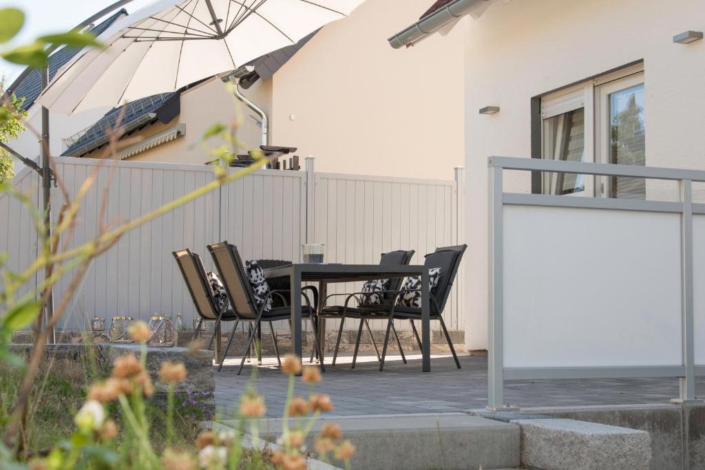 a patio with a table and chairs and an umbrella at Location 1 in Rimschweiler