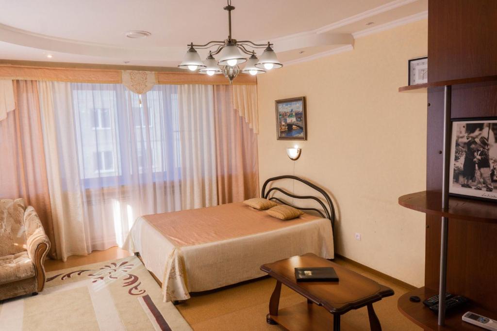 オムスクにあるHotel Na Svetlomのベッドルーム1室(ベッド1台、テーブル、窓付)