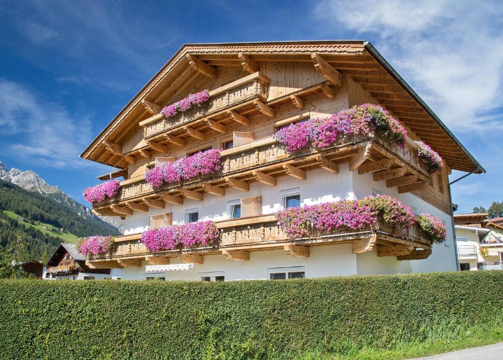 a building with flowers on the side of it at Pension Mariandl in Neustift im Stubaital