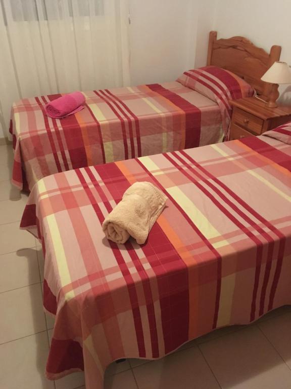 Dos camas con una toalla encima. en EVA & TRAVEL - Marcel Riumar Apartamento, en Riumar