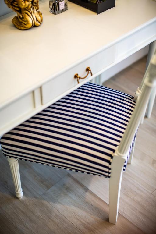 A striped upholstered chair tucked beneath a white console or desk.