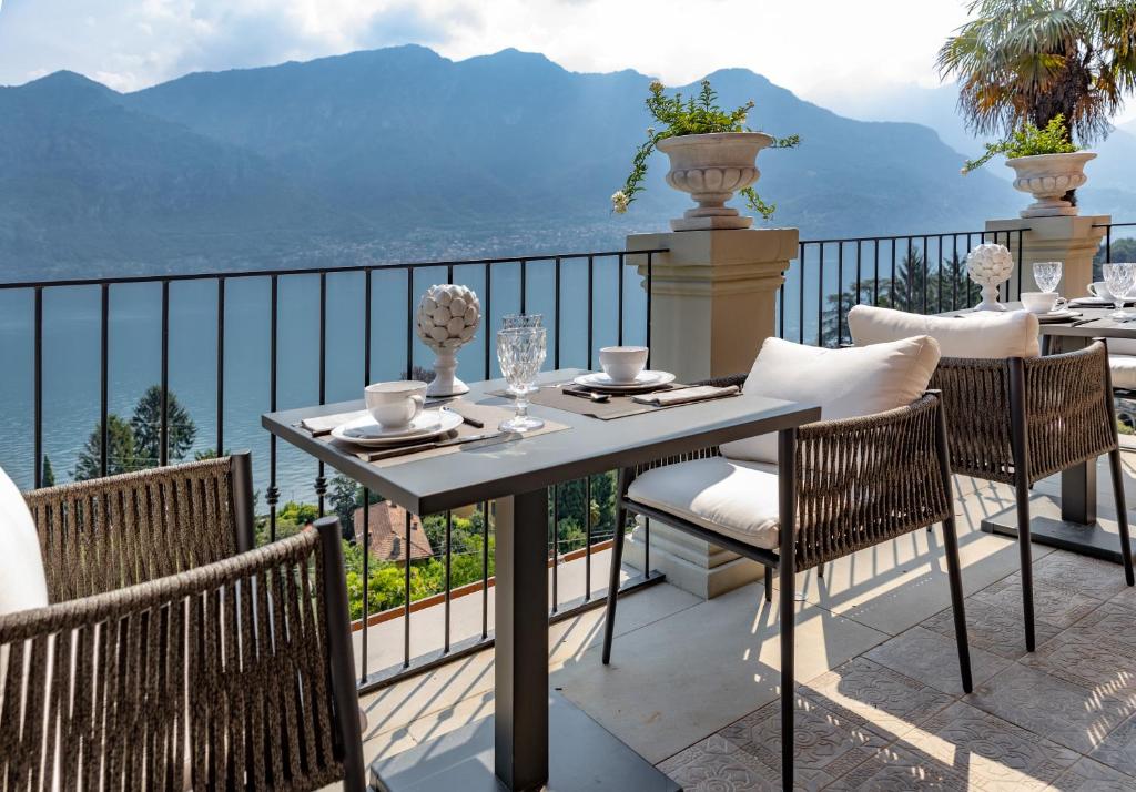 uma mesa e cadeiras numa varanda com vista em Villa Mojana Bellagio em Oliveto Lario