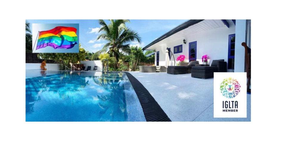 a villa with a swimming pool in front of a house at Phuket Gay Homestay in Kathu