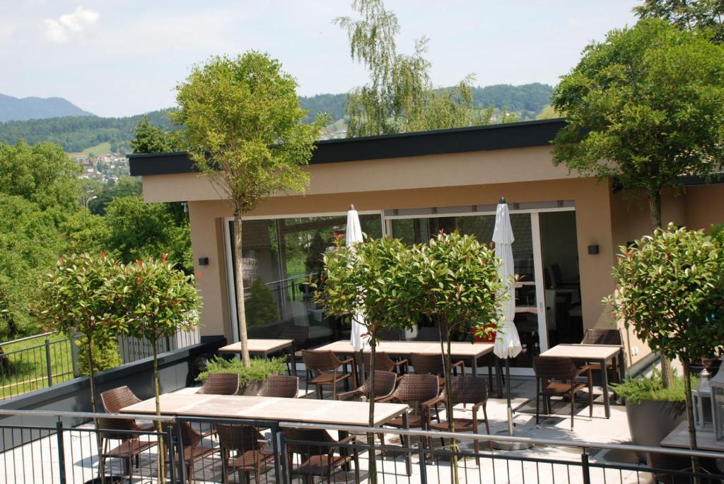 ein Restaurant mit Tischen und Stühlen auf einem Balkon in der Unterkunft Hotel Weinstube in Nendeln