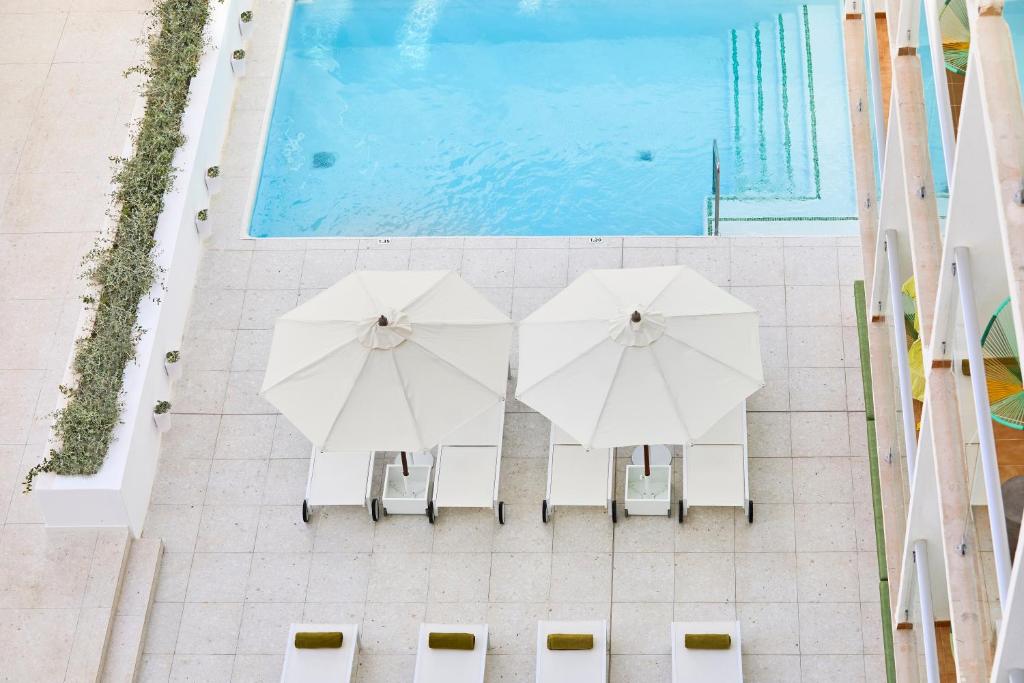 een uitzicht op twee witte parasols naast een zwembad bij HM Dunas Blancas in Playa de Palma