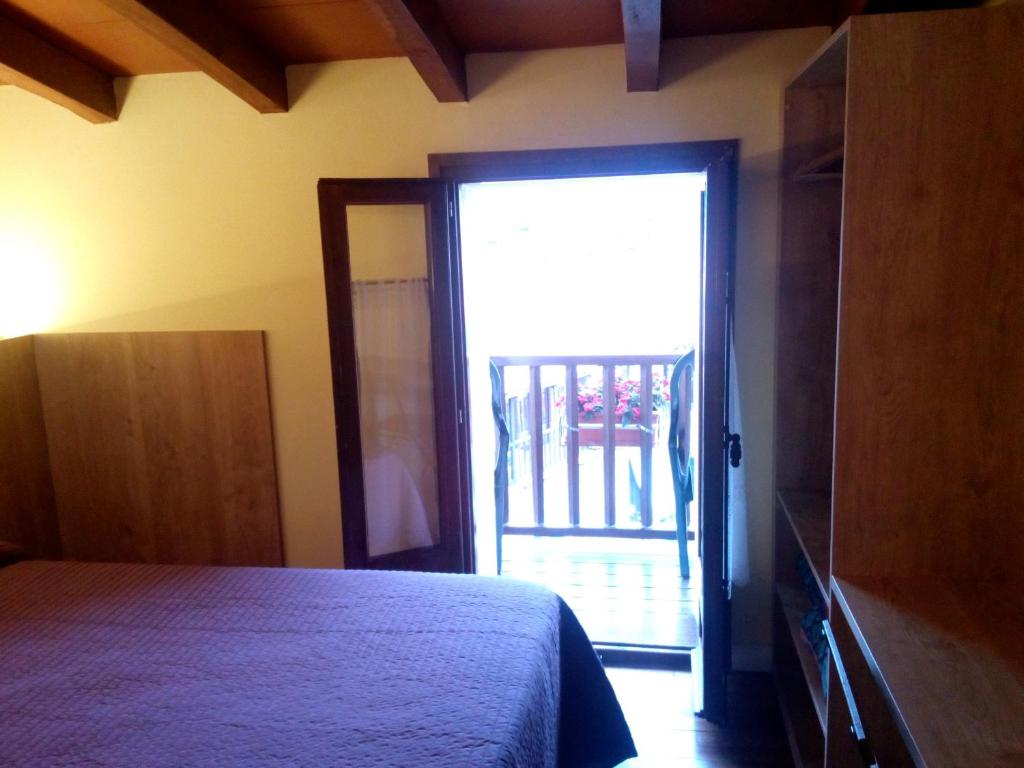 a bedroom with a bed and a sliding glass door at CAN MENCIÓ - Plaça Major in Santa Pau
