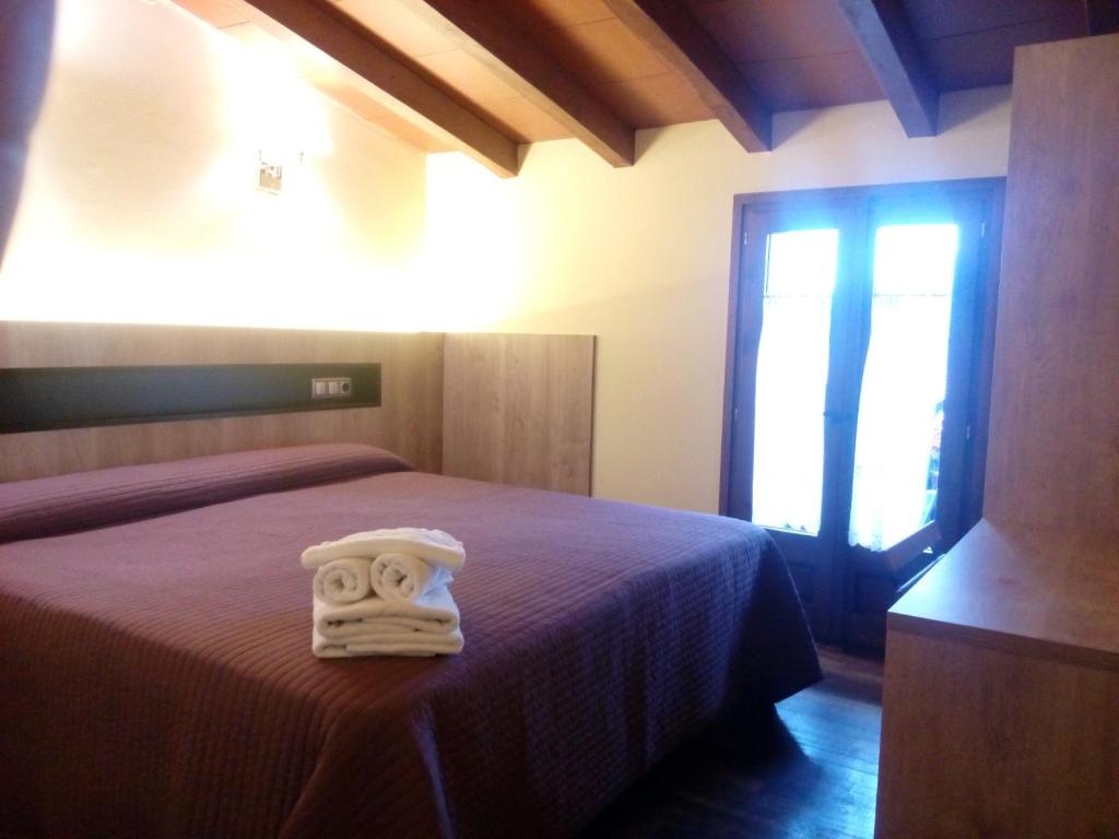 a bedroom with a bed with a towel on it at CAN MENCIÓ - Plaça Major in Santa Pau