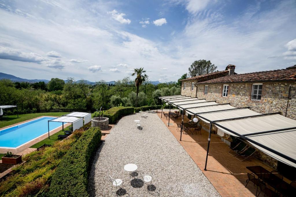 an outdoor patio with tables and umbrellas next to a building at Appartamento con magnifica vista e piscina in Lucca