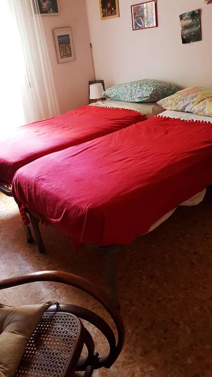 two beds in a room with a red blanket at CozyandCalm in Florence