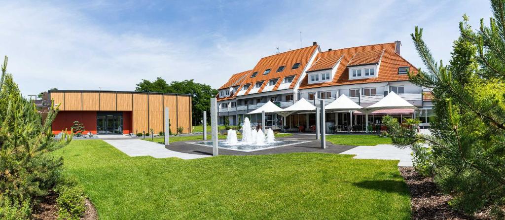 a building with a fountain in the middle of a park at Europe Haguenau – Hotel & Spa in Haguenau