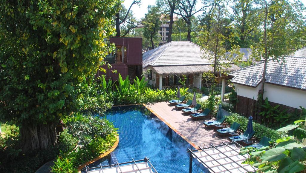 an aerial view of a swimming pool with lounge chairs and a house at La Rivière d' Angkor Resort in Siem Reap