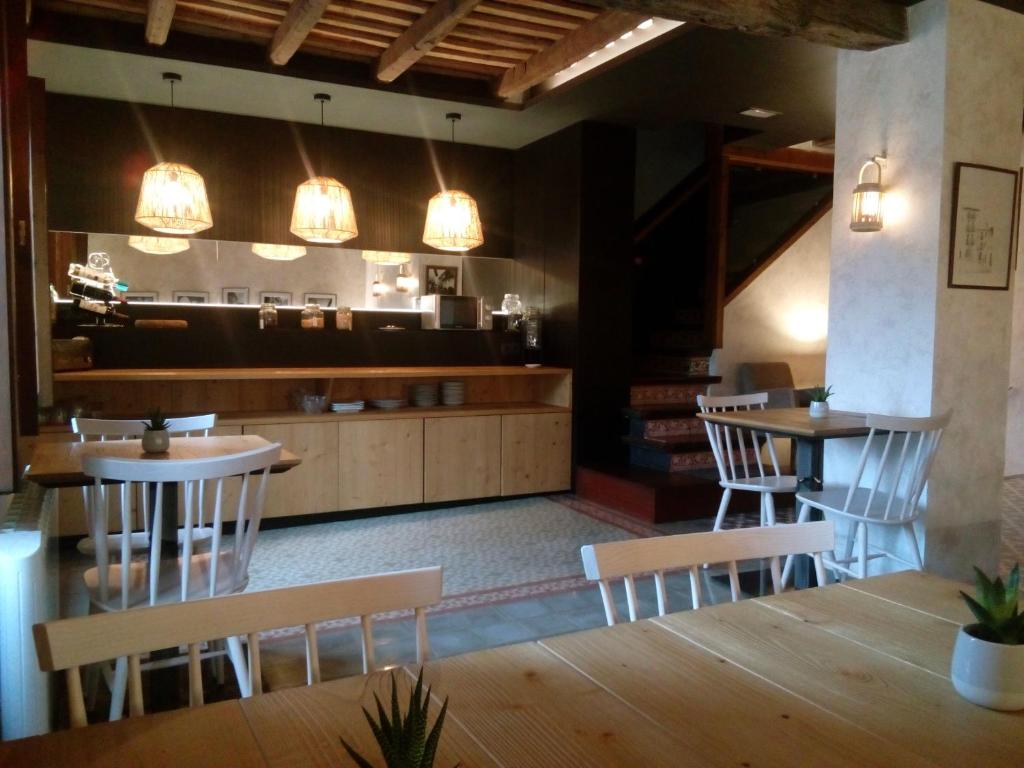 a restaurant with tables and chairs and lights at CAN MENCIÓ - Plaça Major in Santa Pau