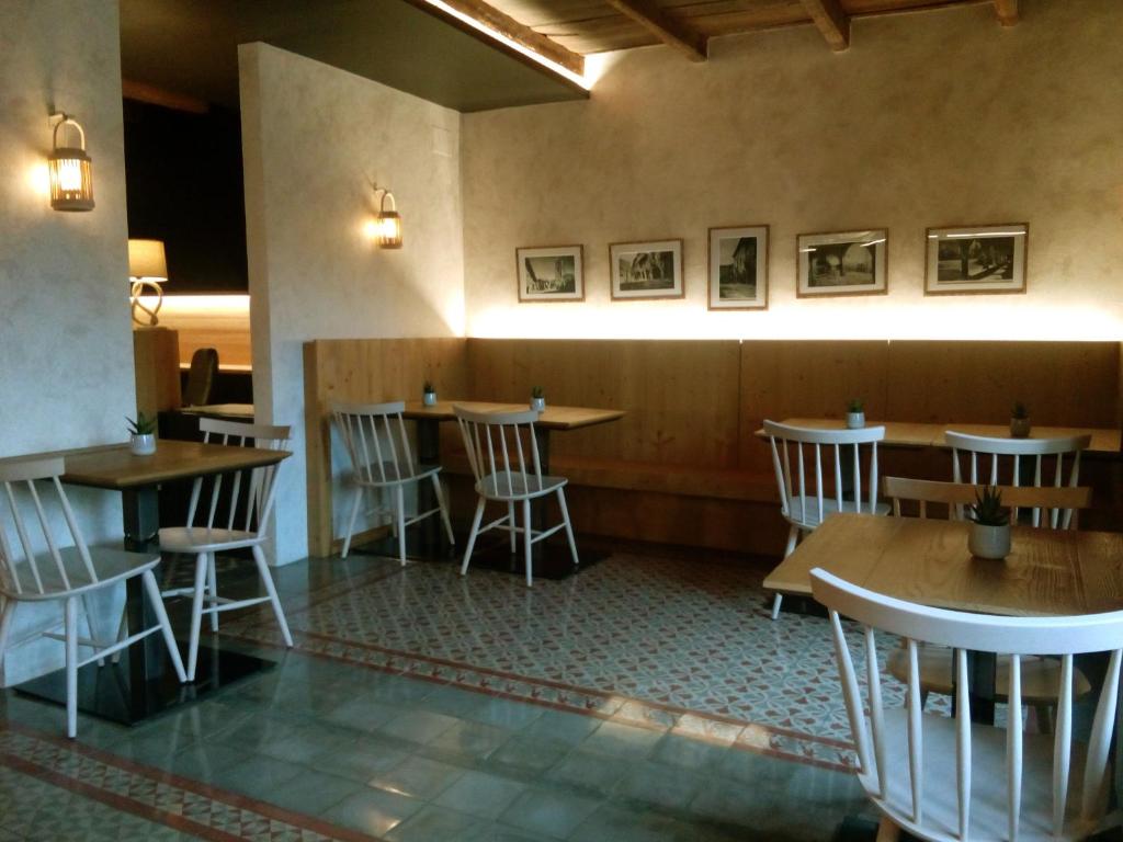 a restaurant with tables and chairs in a room at CAN MENCIÓ - Plaça Major in Santa Pau