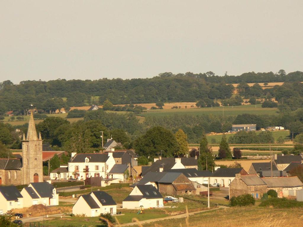 a small town with houses and a church and trees at La ferme de la Cavalerie in Saint-Gonnery