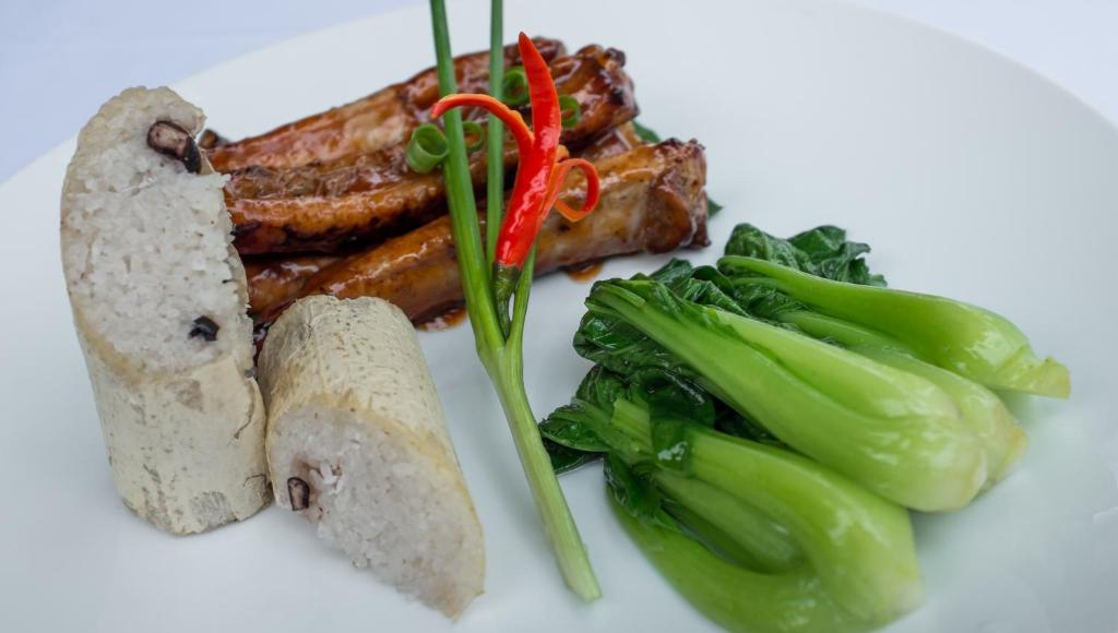 a white plate of food with meat and vegetables at La Rivière d' Angkor Resort in Siem Reap