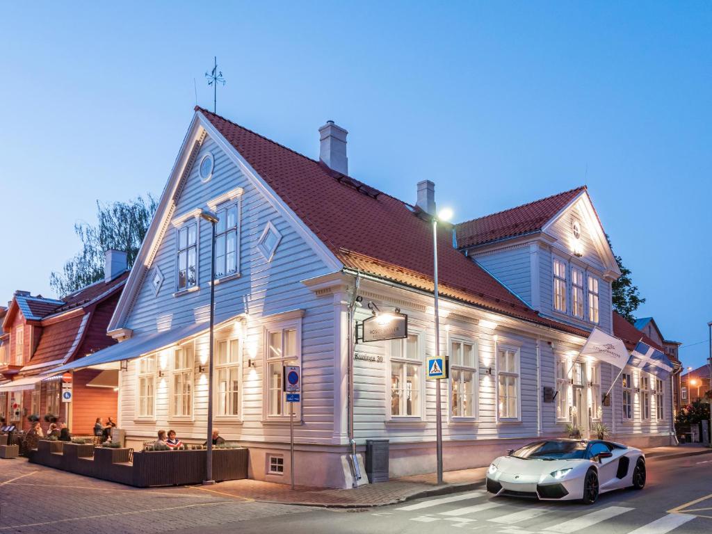 um carro branco estacionado em frente a um edifício em Boutique Hotel Rosenplänter em Pärnu