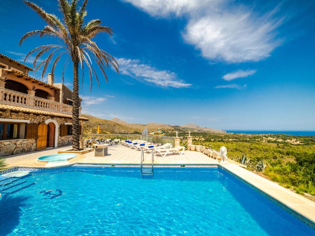 a villa with a swimming pool and a palm tree at Villa Cala Torta Na Lluny by Interhome in Cala Mesquida
