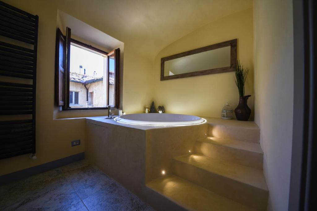 baño con bañera grande y ventana en Il Sogno di Annalisa Suite, en Volterra
