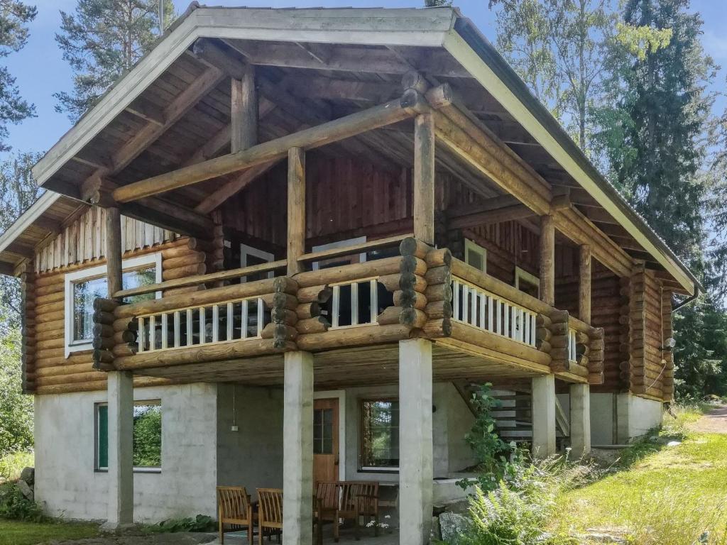 ein Blockhaus mit einer umlaufenden Veranda und einer umlaufenden Terrasse in der Unterkunft Holiday Home Kalliokoivu by Interhome in Torvoila
