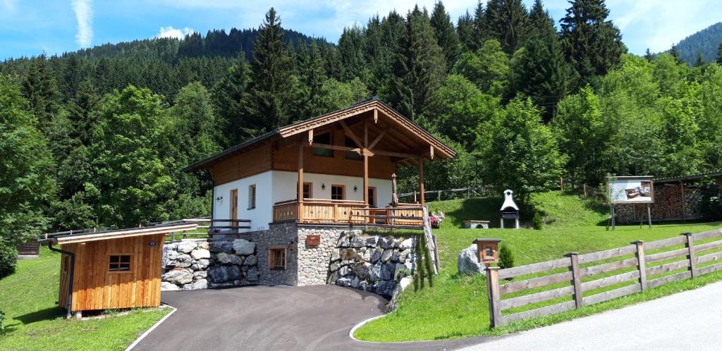 ein Haus auf einem Hügel mit einem Zaun in der Unterkunft Chalet Freiraum in Kleinarl