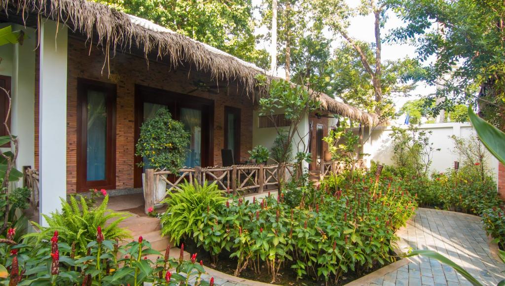 a house with a garden in front of it at La Rivière d' Angkor Resort in Siem Reap
