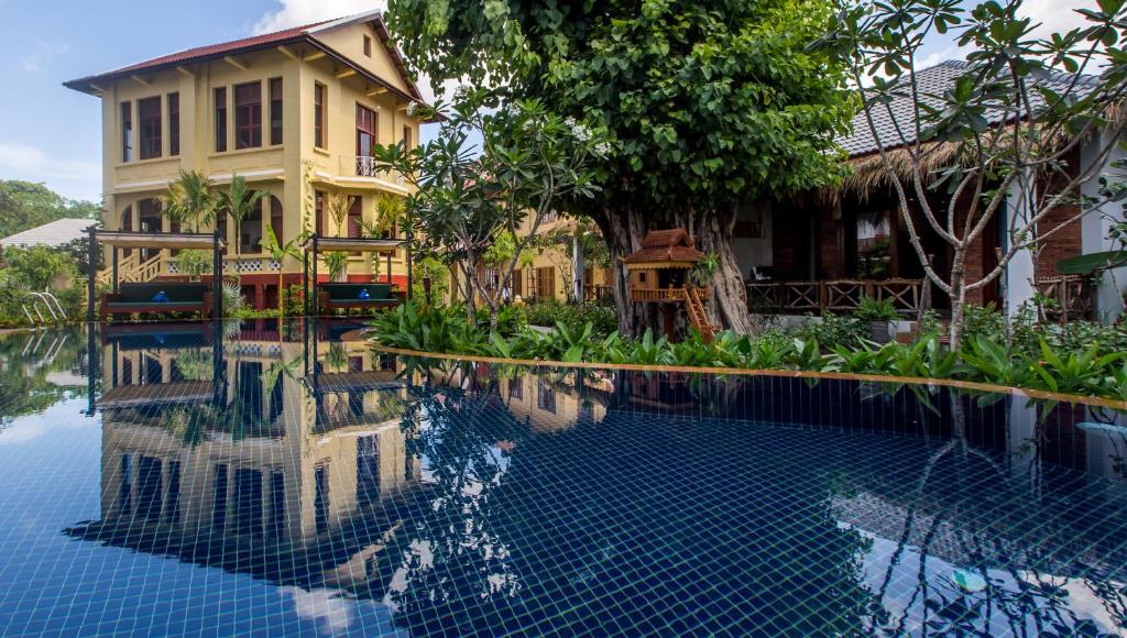 a house and a swimming pool in front of a house at La Rivière d' Angkor Resort in Siem Reap
