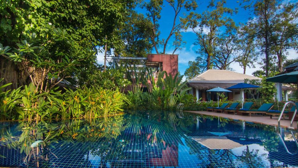 a pool at a resort with chairs and a gazebo at La Rivière d' Angkor Resort in Siem Reap