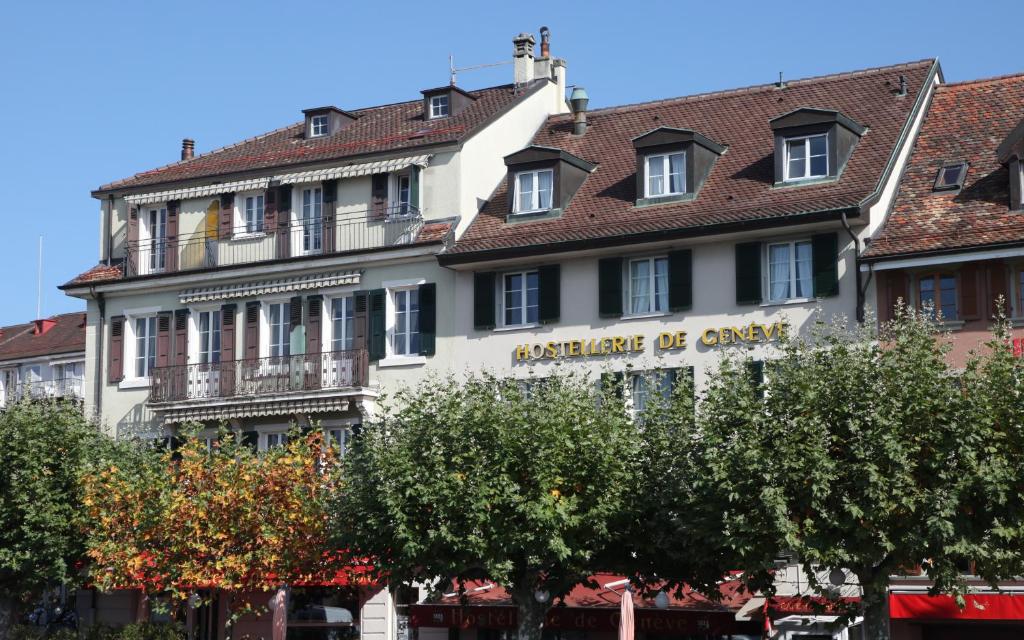 ein großes weißes Gebäude mit einem Schild drauf in der Unterkunft Hostellerie de Genève in Vevey