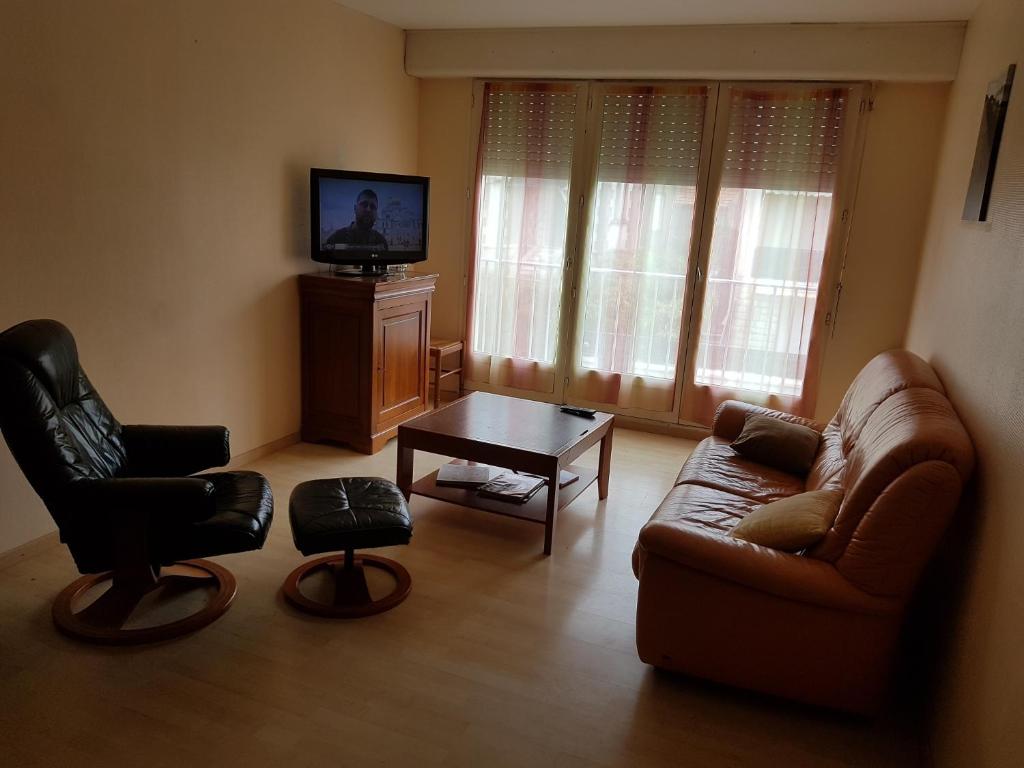 een woonkamer met een bank, een stoel en een tafel bij Royan plage in Royan
