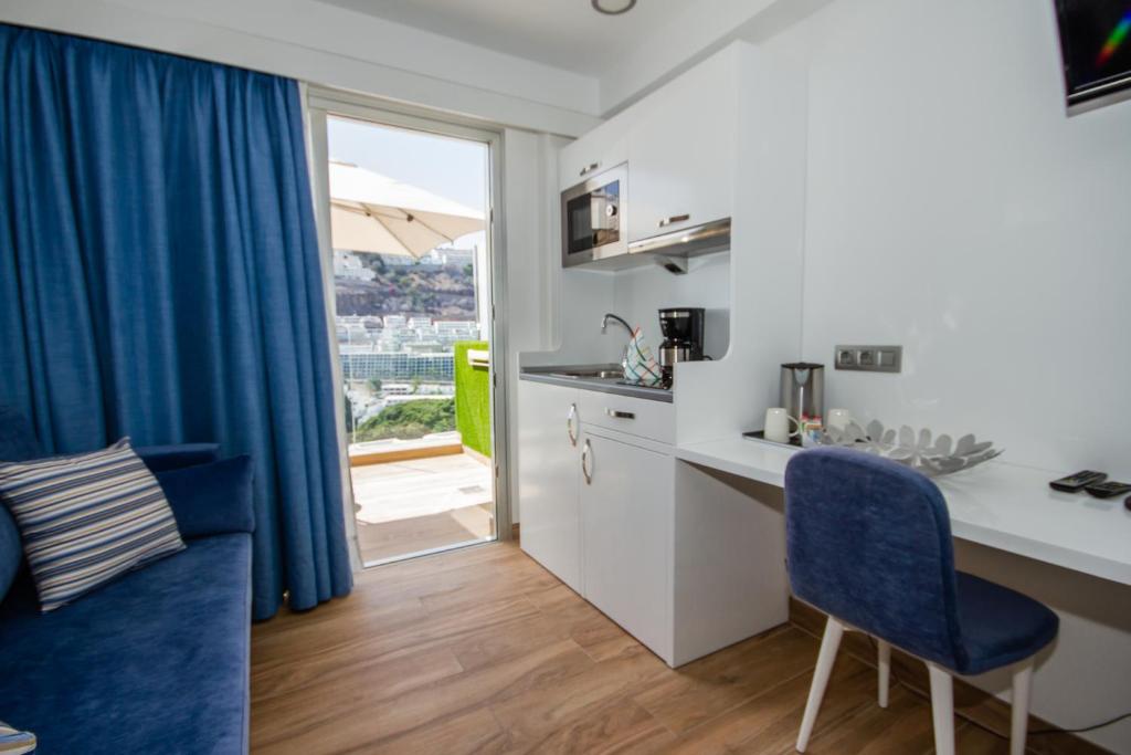 a kitchen with a desk and a table and chairs at IG Nachosol Atlantic & Yaizasol by Servatur - Adults Only in Puerto Rico de Gran Canaria